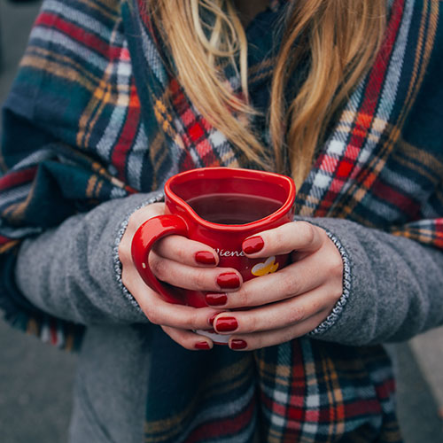 Woman holding heart-shaped mug